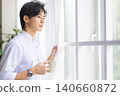 A man looking out the window 140660872