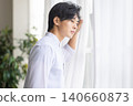 A man looking out the window 140660873