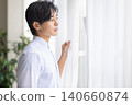 A man looking out the window 140660874