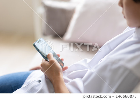 A man's hand looking at a smartphone 140660875