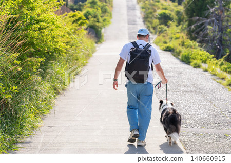 A man walking his Border Collie from behind. 140660915