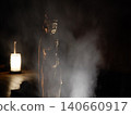 Buddhist and Kannon statues illuminated in the darkness, shrouded in smoke (mist). 140660917