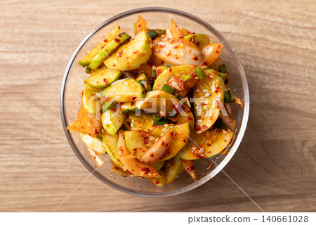 Korean cucumber salad in a glass bowl on wooden background, Table top view Korean cucumber salad in a glass bowl on wooden background, Table top view 140661028