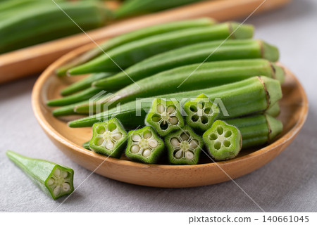 Fresh green okra on wooden plate, concept for organic vegetables and healthy eating Fresh green okra on wooden plate, concept for organic vegetables and healthy eating 140661045