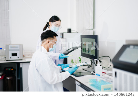 Male nutritionist in lab coat analyzing food and writing in notebook. Healthy eating, organic testing, and nutrition science 140661242
