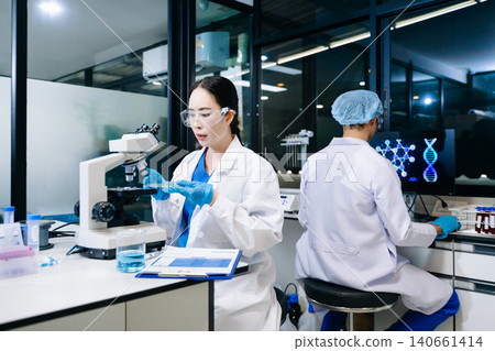 Team of scientists analyzing blue liquid samples in a modern lab, showcasing biotechnology, chemistry, and medical research innovation. Team of scientists analyzing blue liquid samples in a modern lab, showcasing biotechnology, chemistry, and medical research innovation. 140661414