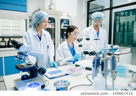 Team scientist or medical technician working, having a medical discuss meeting with an Asian senior female scientist supervisor Team scientist or medical technician working, having a medical discuss meeting with an Asian senior female scientist supervisor 140661418