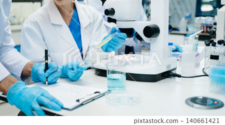 Scientist Team Working in Medical Laboratory with Futuristic HUD Interface Scientist Team Working in Medical Laboratory with Futuristic HUD Interface 140661421