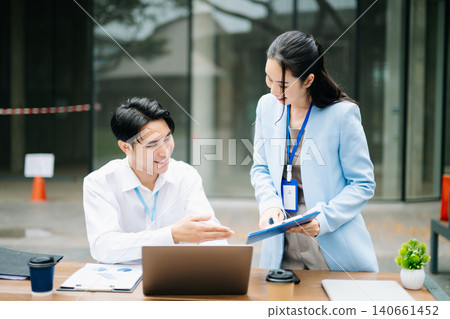 Business colleagues reviewing reports on laptop and smartphone, corporate teamwork, mobile office, startup collaboration, digital communication and productivity concept. 140661452