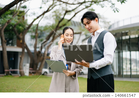 Businessman and woman going in city center in smart casual business style, talking, working together, stylish freelance people, holding coffee and laptop,tablet Businessman and woman going in city center in smart casual business style, talking, working together, stylish freelance people, holding coffee and laptop,tablet 140661547