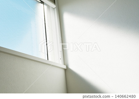 A background photograph of a minimalist and bright interior, featuring light streaming in through a window, white walls, and a window. A background photograph of a minimalist and bright interior, featuring light streaming in through a window, white walls, and a window. 140662480