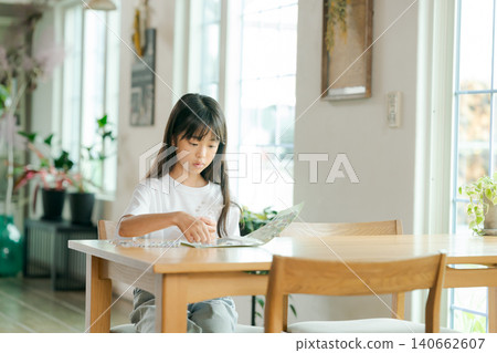 一個女孩在玩貼紙書 一個女孩在玩貼紙書 140662607