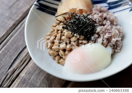 Natto rice with sixteen grains, topped with a soft-boiled egg and pickled young ginger. Natto rice with sixteen grains, topped with a soft-boiled egg and pickled young ginger. 140663398