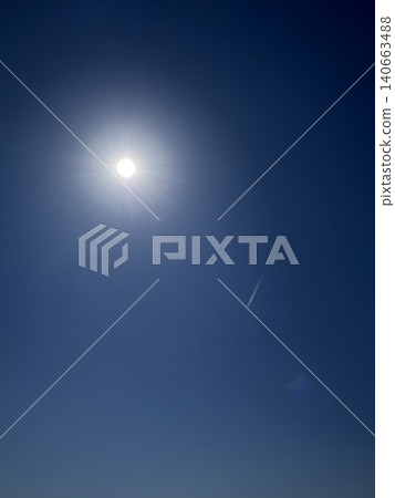 The sun shines brightly in the clear blue sky. 140663488