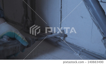 Worker Applying Sealant Along Floor Seam With Gloved Hand, Smoothing Bead Of Silicone Between Tile And Wall Using Caulking Tool, Dim Worksite Lighting And Focused Manual Motion Conveying Worker Applying Sealant Along Floor Seam With Gloved Hand, Smoothing Bead Of Silicone Between Tile And Wall Using Caulking Tool, Dim Worksite Lighting And Focused Manual Motion Conveying 140663490