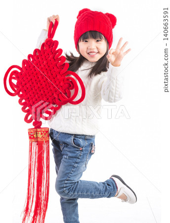 Happy Asian little girl holding a large Chinese knot ornament isolated on white background, celebrating Lunar New Year.There is a Chinese character on it: "Fu" (Good Fortune). 140663591