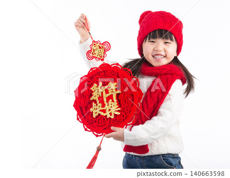 Little Chinese girl holding a red decoration with "Happy New Year" calligraphy, celebrating traditional spring festival. Little Chinese girl holding a red decoration with "Happy New Year" calligraphy, celebrating traditional spring festival. 140663598