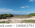A clear blue sky and a shallow beach with tide pools still remaining. 140663791