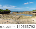 A clear blue sky and a shallow beach with tide pools still remaining. 140663792