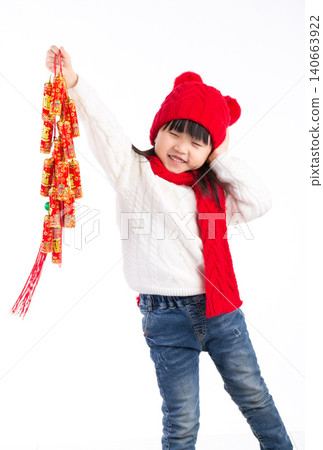 Cute Asian girl in red dress holding firecracker decorations and smiling, Chinese New Year celebration concept. Cute Asian girl in red dress holding firecracker decorations and smiling, Chinese New Year celebration concept. 140663922