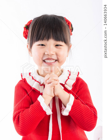 Cute Asian girl in red sweater making a traditional greeting gesture for Chinese New Year, Kung Hei Fat Choy. Cute Asian girl in red sweater making a traditional greeting gesture for Chinese New Year, Kung Hei Fat Choy. 140663934