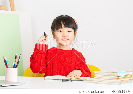 Intelligent Chinese girl doing homework at desk, thinking deeply and having a great idea or eureka moment. Intelligent Chinese girl doing homework at desk, thinking deeply and having a great idea or eureka moment. 140663939