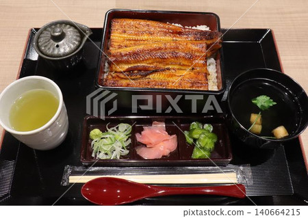 一套精緻的日式料理套餐，包括鰻魚飯和湯。 140664215