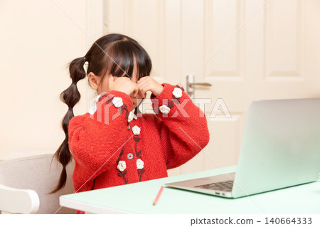 asian little girl doing eye exercises to relax eyes during online learning at home, healthy study habits concept asian little girl doing eye exercises to relax eyes during online learning at home, healthy study habits concept 140664333