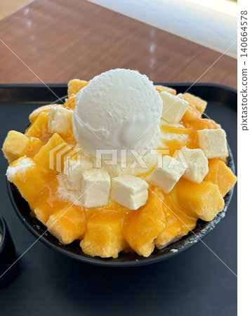 Refreshing mango bingsu with fluffy shaved ice, sweet mango chunks, and creamy condensed milk. A perfect Korean dessert for hot days, offering a delightful balance of fruity and creamy flavors! Refreshing mango bingsu with fluffy shaved ice, sweet mango chunks, and creamy condensed milk. A perfect Korean dessert for hot days, offering a delightful balance of fruity and creamy flavors! 140664578