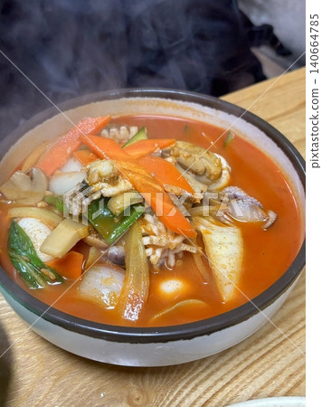 A steaming bowl of jjampong, the spicy Korean-Chinese noodle soup loaded with seafood, vegetables, and rich, flavorful broth. A hearty and satisfying comfort dish. 140664785