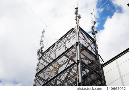 Ornate wrought iron tower against cloudy blue sky Ornate wrought iron tower against cloudy blue sky 140665032