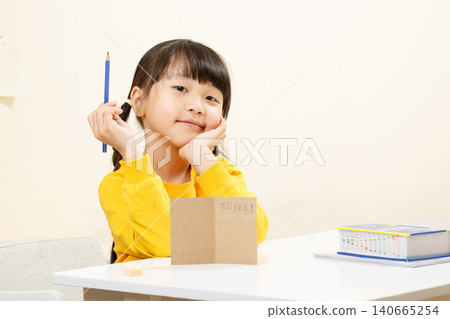 Happy Asian Girl Sitting at Desk, Studying and Learning at Home Happy Asian Girl Sitting at Desk, Studying and Learning at Home 140665254
