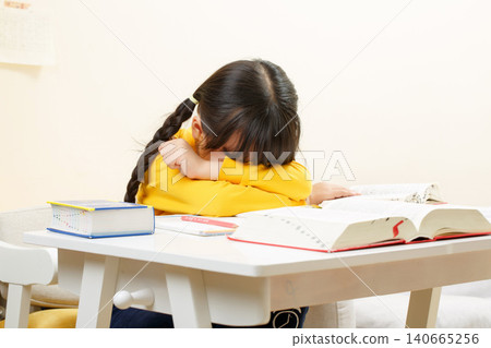 Tired Asian Girl Doing Homework at Desk, School Study and Learning Concept Tired Asian Girl Doing Homework at Desk, School Study and Learning Concept 140665256