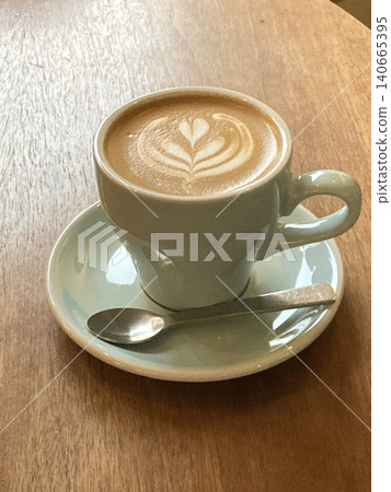 A beautifully crafted latte, featuring creamy foam art on top of rich espresso. Perfect for coffee-related projects, this image captures the warmth and inviting nature of a classic cafe experience. A beautifully crafted latte, featuring creamy foam art on top of rich espresso. Perfect for coffee-related projects, this image captures the warmth and inviting nature of a classic cafe experience. 140665395