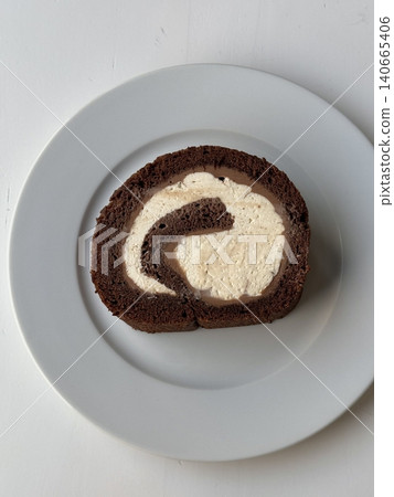 Soft roll cake with fluffy sponge layers and creamy filling spiraled inside, showcasing smooth texture, delicate shape, and sweet inviting appearance in close-up detail 140665406