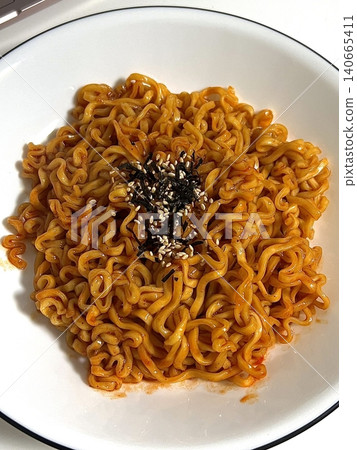 Spicy buldak ramyeon with fiery hot sauce and chewy noodles, delivering an intense, flavorful kick in every bite. A perfect choice for those who crave bold, spicy Korean comfort food. Spicy buldak ramyeon with fiery hot sauce and chewy noodles, delivering an intense, flavorful kick in every bite. A perfect choice for those who crave bold, spicy Korean comfort food. 140665411