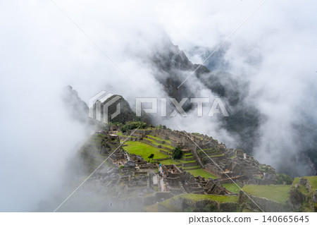 Panoramic view of Machu Picchu ruins surrounded by misty mountains, Peru Panoramic view of Machu Picchu ruins surrounded by misty mountains, Peru 140665645