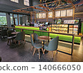 Modern coffee shop interior featuring a vibrant illuminated green service counter, stylish wooden bar. 140666050