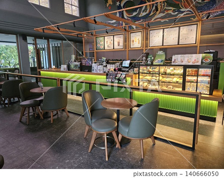 Modern coffee shop interior featuring a vibrant illuminated green service counter, stylish wooden bar. Modern coffee shop interior featuring a vibrant illuminated green service counter, stylish wooden bar. 140666050