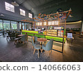 Modern coffee shop interior featuring a vibrant illuminated green service counter, stylish wooden bar. 140666063