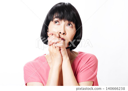 一位留著波波頭的中年婦女正在祈禱 140666238