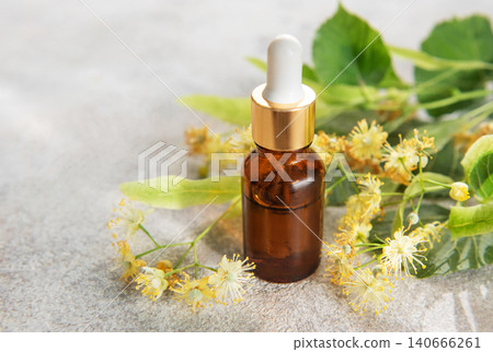 Linden essential oil in dropper bottle with fresh flowers 140666261
