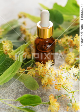 Linden essential oil in dropper bottle with fresh flowers 140666262