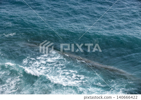 Aerial view of turquoise ocean waves crashing over a reef 140666422