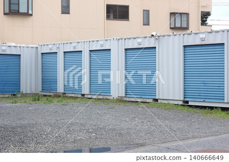 The exterior of the white rental storage space features a distinctive blue shutter door. The exterior of the white rental storage space features a distinctive blue shutter door. 140666649