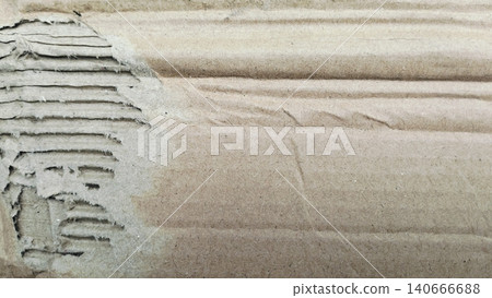 Close-up of damaged brown kraft paperboard, rustic grunge corrugated material. Close-up of damaged brown kraft paperboard, rustic grunge corrugated material. 140666688
