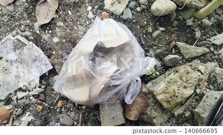 Plastic bag filled with garbage abandoned on dirty soil ground. 140666695