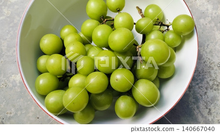 Fresh green Shine Muscat grapes bunch in a white bowl 140667040