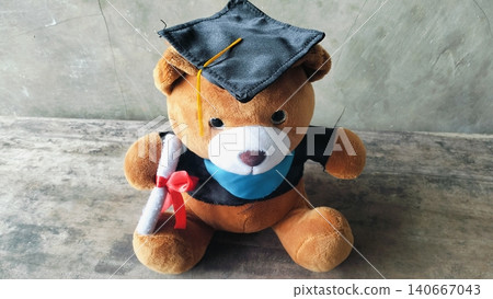 Cute graduation teddy bear doll sitting on wooden bench. Cute graduation teddy bear doll sitting on wooden bench. 140667043
