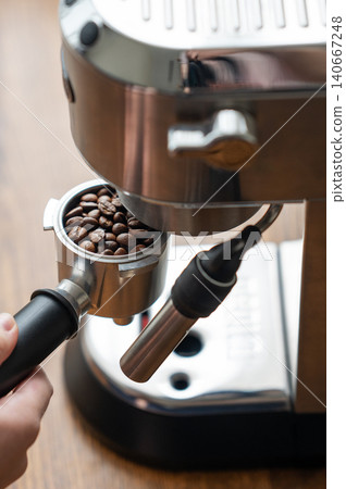 Preparing espresso with portafilter and home coffee machine in natural sunlight Preparing espresso with portafilter and home coffee machine in natural sunlight 140667248